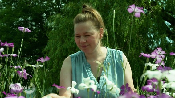 Die Landschaftsgärtnerin Leonie Korbach steht in ihrem Blumenfeld. © Screenshot 