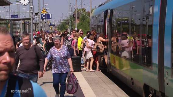 Viele Menschen drängen am Bahnsteig in einen haltenden Zug. © Screenshot 