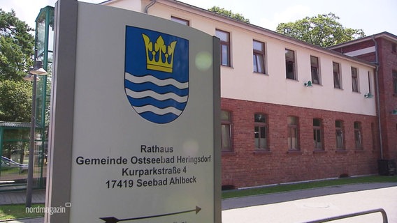 Ein Schild mit Stadtwappen weist zum Rathaus der Gemeinde Ostseebad Heringsdorf. © Screenshot 