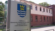 Ein Schild mit Stadtwappen weist zum Rathaus der Gemeinde Ostseebad Heringsdorf. © Screenshot 