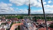 Mit einem Spezialkran wird eine Turmspitze wieder an ihren Ursprungsort auf dem Helmstedter Juleum gesetzt. © Screenshot 