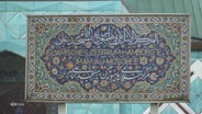 Auf einem Schild vor der Blauen Moschee in Hamburg steht "Islamisches Zentrum Hamburg e.V. Imam Ali Moschee". © Screenshot 