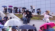 Zahlreiche Taylor Swift Fans tanzen während des Konzerts gemeinsam im Regen vor dem Volksparkstadion. © Screenshot 