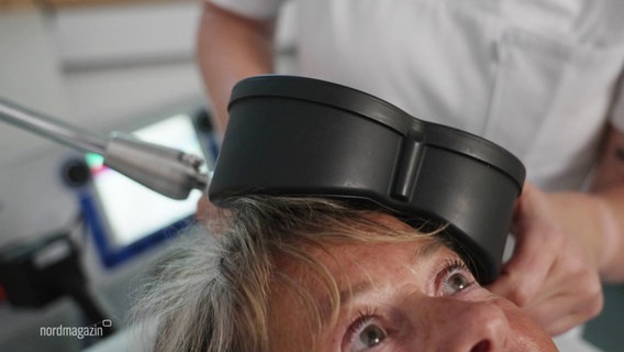 Eine Patientin wird mit einer Magnetspule am Kopf behandelt. © Screenshot 