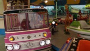 Der pinke Miniatur-Bus des Kinderkarussells von Familie Scholle auf dem Hamburger DOM. © Screenshot 
