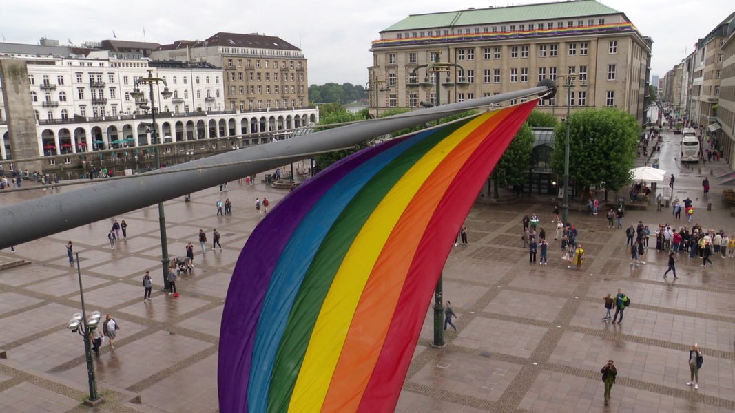 Blick vom Balkon des Hamburger Rathauses auf die dort gehisste Regenbogenflagge und den Rathausmarkt.