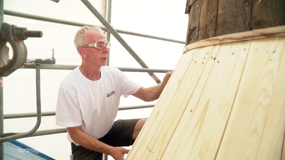 Ein Mann mit Brille auf der Baustelle des Wasserturms. © Screenshot 