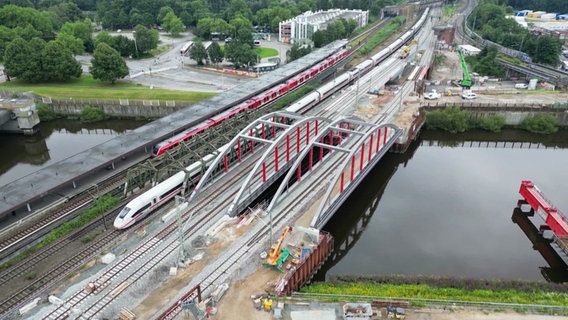 Züge fahren an zwei neuen Bahnbrücken auf der Veddel vorbei. © Screenshot 