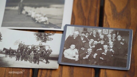 Historische Fotos der Schweriner Rudergesellschaft liegen auf einem Tisch. © Screenshot 