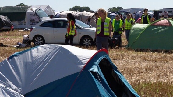 Personen auf einem Platz voller Zelte. © Screenshot 