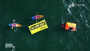 Ein Greenpeace-Banner mit der Aufschrift "No new gas!" wird von zwei Booten auf dem Wasser ausgebreitet. © Screenshot 