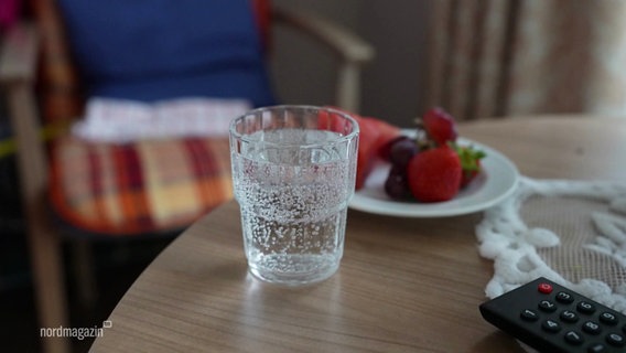 Ein Wasserglas steht auf einem Tisch. © Screenshot 