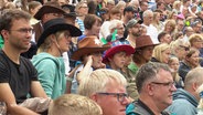 Viele Zuschauerinnen einer Veranstaltung, einige davon mit Cowboy-Hütten. © Screenshot 