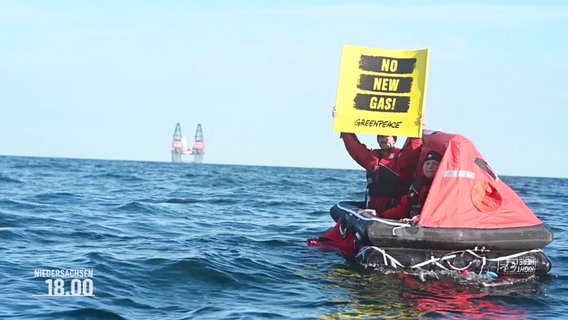 Eine Person in einem Schlauchboot hält ein Schild mit der Aufschrift: "No new gas!". © Screenshot 