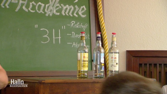 Drei Flaschen Schnaps stehen auf einer Anrichte in der "Korn-Akademie". © Screenshot 