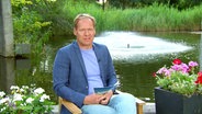 Thilo Tautz moderiert das Nordmagazin sitzend im Garten. © Screenshot 