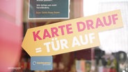 Ein Schild des Tante-Enso-Supermarkts mit der Aufschrift "Karte drauf, Tür auf". © Screenshot 