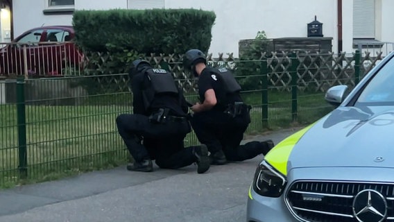 Polizeibeamte an einem Zaun. © Screenshot 
