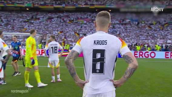 Toni Kroos steht in einem Stadion und hat die Hände auf die Hüften gestützt. © Screenshot 