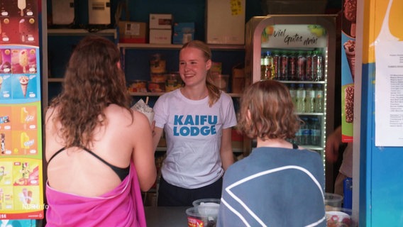 Am Freibadkiosk kaufen zwei junge Frauen eine Tüte Pommes. © Screenshot 