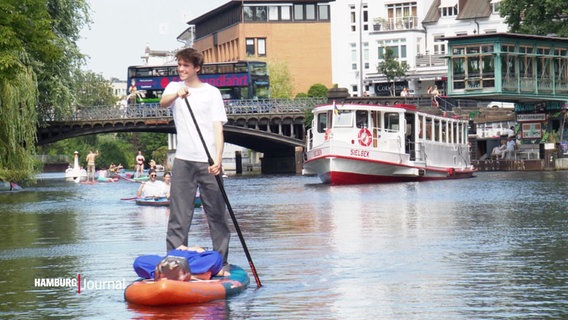 Ein junger Mann fährt mit einem SUP auf der Alster. © Screenshot 