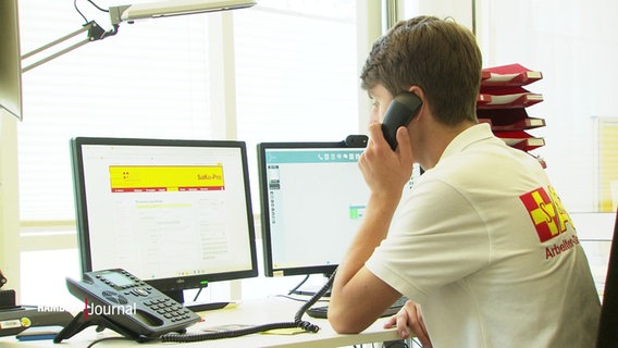 Ein junger Mann sitzt vor einem Monitor und telefoniert. © Screenshot 