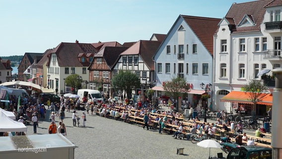 Menschen essen gemeinsam an einer langen Tafel. © Screenshot 