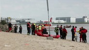 Mehrere Einsatzkräfte am Hamburger Elbstrand. © Screenshot 