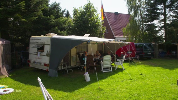 Ein Wohnwagen in einem Garten. © Screenshot 