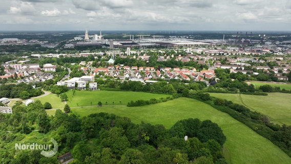 Panoramaansicht über das Braunschweiger Land. Grüne Wiesen, im Hintergrund eine Stadt. © Screenshot 