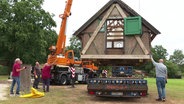 Ein altes Fachwerk-Backhaus hängt an einem Kran. © Screenshot 