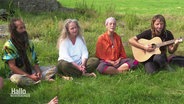 Teinehmer:innen des Rainbow-Family-Camps meditieren und singen. © Screenshot 