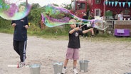 Ein Kind macht Seifenblasen beim LÜTTville Festival. © Screenshot 