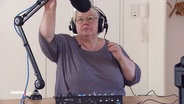 Die ehemalige Dozentin Ulrike stellt das Mikro für eine Podcast-Aufnahme ein. © Screenshot 