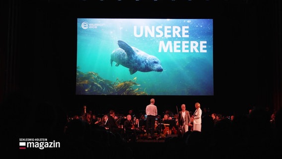 NDR Radiophilharmonie begleitet live Doku "Unsere Meere" in einem Konzertsaal. © Screenshot 