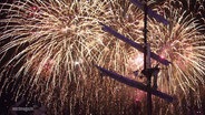 Ein Feuerwerk erleuchtet den Nachthimmel über einem Segelschiff. © Screenshot 