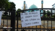 Ein Protestplakat hängt an der geschlossenen Blauen Moschee des IZH. © Screenshot 