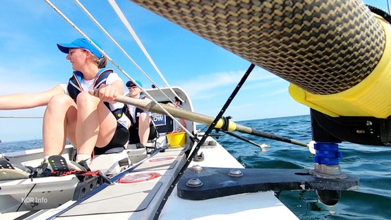 Zwei Frauen sitzen in einem Spezial-Ruderboot. © Screenshot 