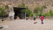 Zwei Personen vor dem Eingang zur Schillat-Höhle. © Screenshot 