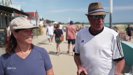 Zwei Personen auf einer Strandpromenade. © Screenshot 