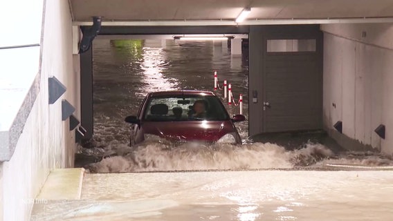 Ein Auto fährt aus einer überschwemmten Tiefgarage. © Screenshot 