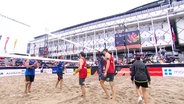 Das deutsche Team Nils Ehlers und Clemens Wickler tragen rote Trikots und klatschen sich mit dem niederländischen Team im blauen Trikot nach dem Match bei der Beachvolleyball-EM 2024 ab. © Screenshot 