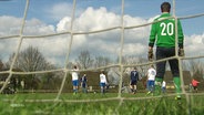 Blick auf ein Fussballspiel durch das Tornetz betrachtet. © Screenshot 