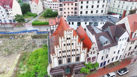 Blick aus der Vogelperspektive auf ein historisches, gotisches Bürgerhaus mit markanter Staffelgiebel-Fassade in einem innerstädtischen Wohnviertel. © Screenshot 