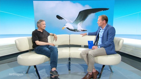 Moderator Thilo Tautz im Gespräch mit Autor Holger Teschke, im Hintergrund: ein Foto einer fliegenden Möwe © Screenshot 