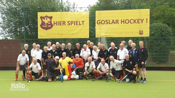 Ü80 Hockeyspieler posieren für ein Mannschaftsfoto. © Screenshot 