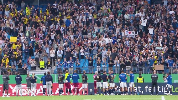 Fans von Phönix Lübeck jubeln ihrer Mannschaft zu. © Screenshot 