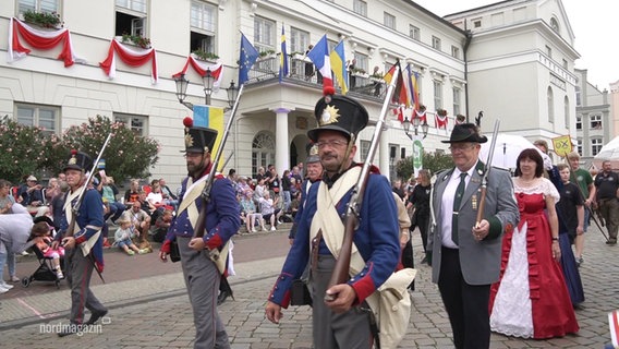 Darsteller in historischen Uniformen bei einem Festumzug. © Screenshot 