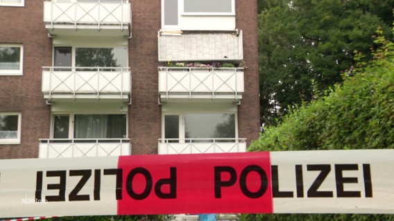 Ein Absperrband der Polizei vor einem Wohnhaus mit abgebrochenem Balkon. © Screenshot 