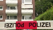 Ein Absperrband der Polizei vor einem Wohnhaus mit abgebrochenem Balkon. © Screenshot 